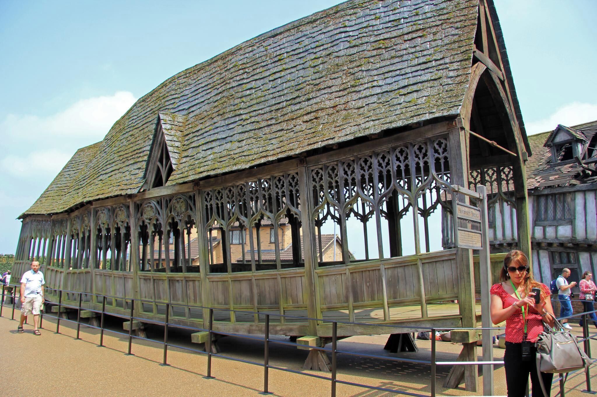 A historic wooden structure with a steeply pitched roof and intricate window designs.
