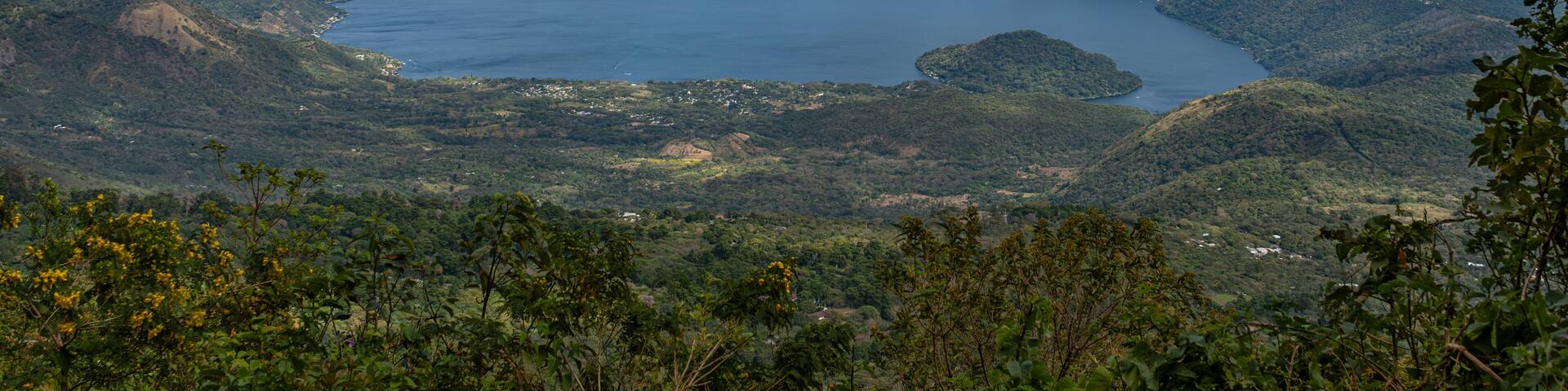 Wide angle panoramic aerial view of Lake Coatepeque with Teopan Island - inactive volcano crater lagoon in western mountain region of El Salvador near Santa Ana city.