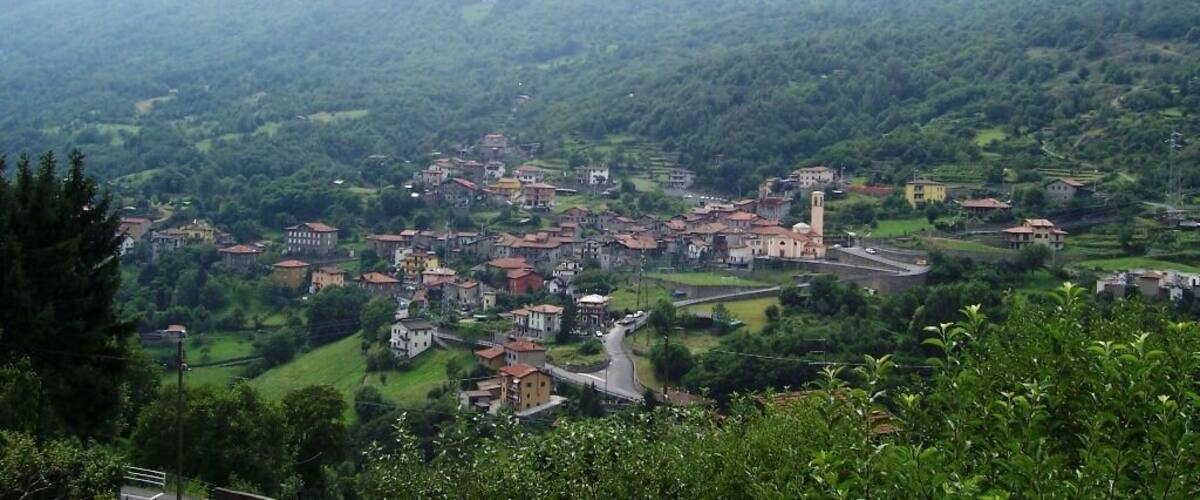 A mountainous village with terraced fields, a prominent church, and scattered houses.