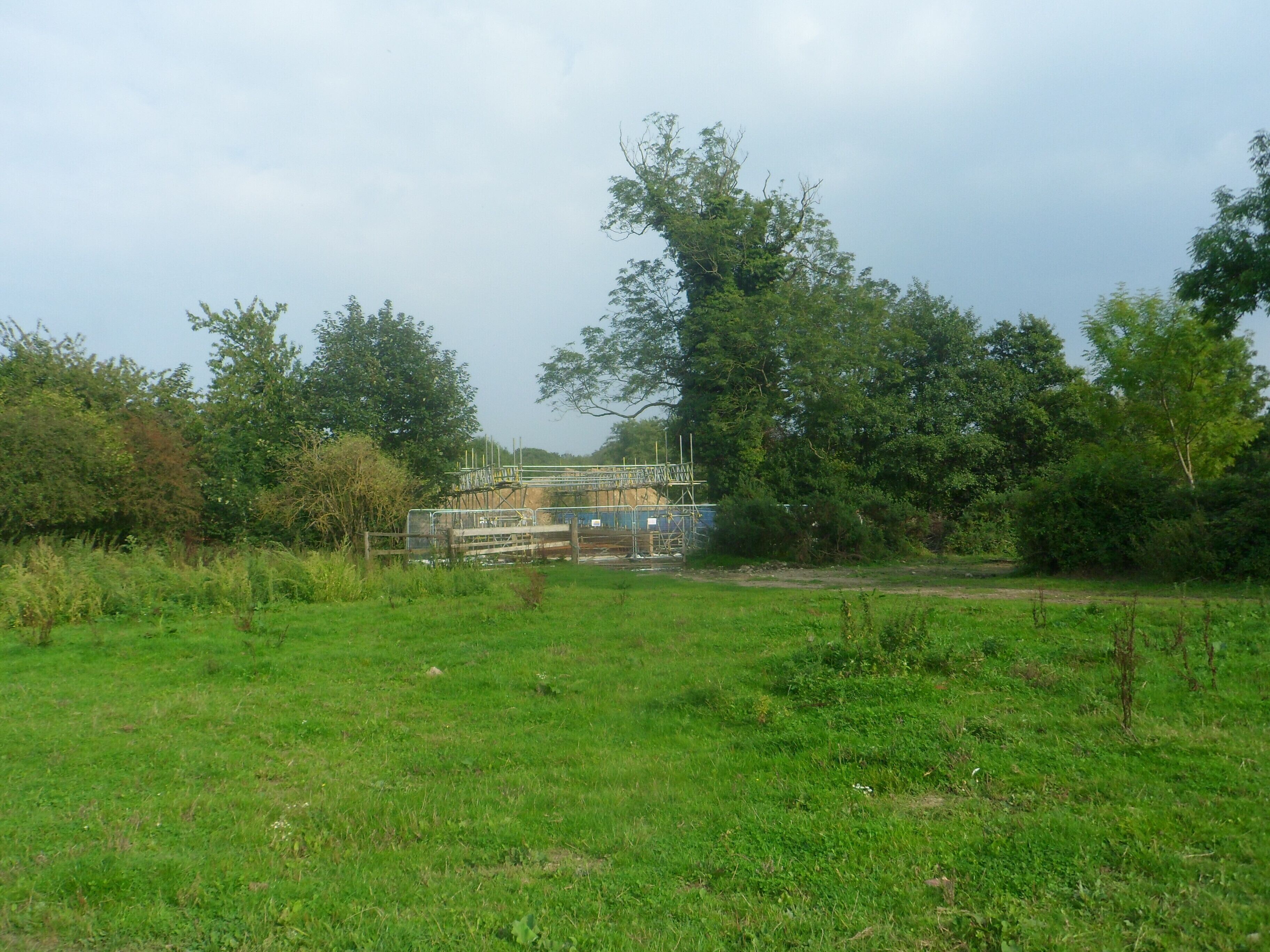 One of a series of photos chronicling the development of Crawley New Town's 14th residential neighbourhood, Forge Wood. This view shows land at the northern end of the Phase 1 development area, shortly before work started in the vicinity. Some building work can be seen directly in front, blocking the public footpath which runs through this field.
