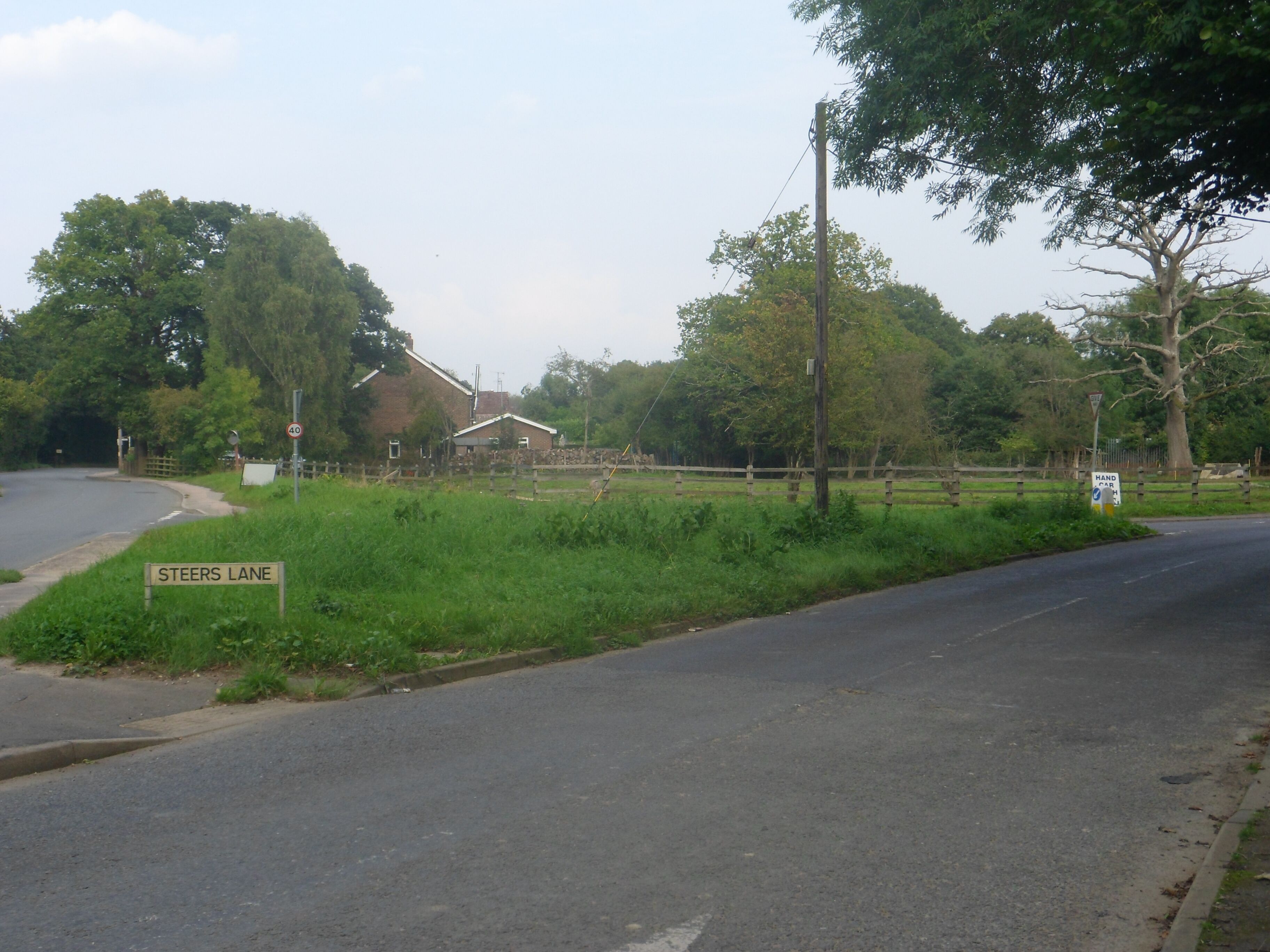 One of a series of photos chronicling the development of Crawley New Town's 14th residential neighbourhood, Forge Wood. This eastward view shows the junction of Radford Road and Steers Lane as it appeared in September 2014, prior to major roadworks which will drastically change its appearance. Radford Road forms the northern limit of the Forge Wood development.