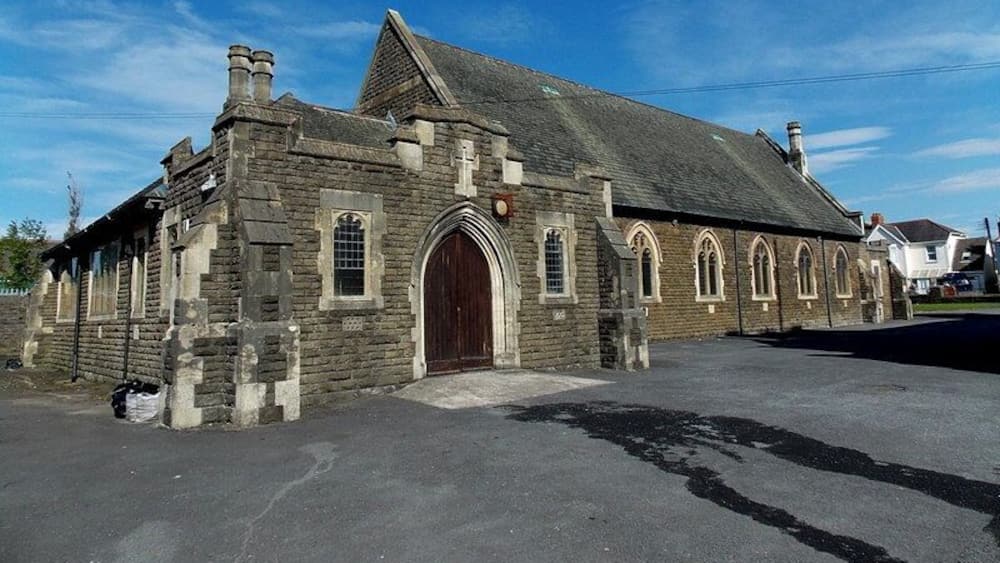 A stone church with a large wooden door and arched windows.