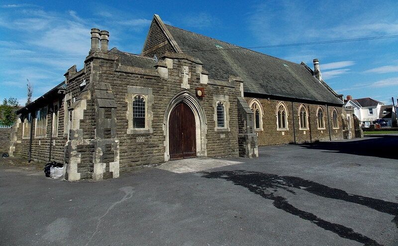 A stone church with a large wooden door and arched windows.