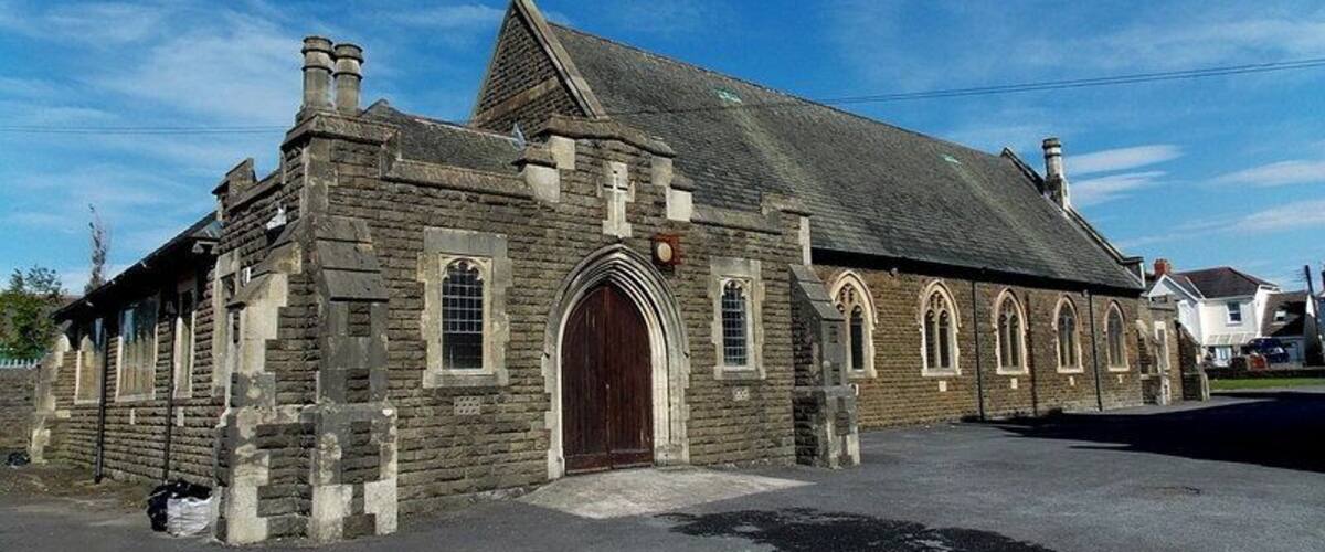 A stone church with a large wooden door and arched windows.