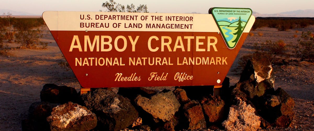 A sign for Amboy Crater National Natural Landmark with the U.S. Department of the Interior Bureau of Land Management logo.