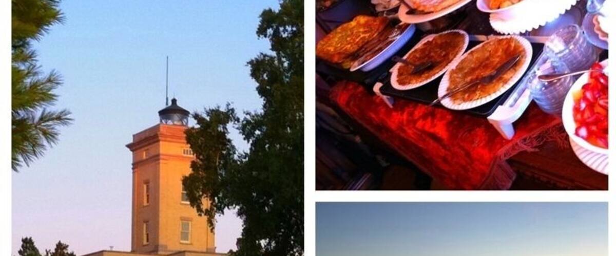 A coastal building, a table with food, and a sunset over the ocean.