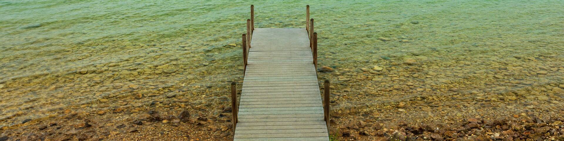 Wooden dock on crystal clear blue Torch Lake in Northern Michigan.