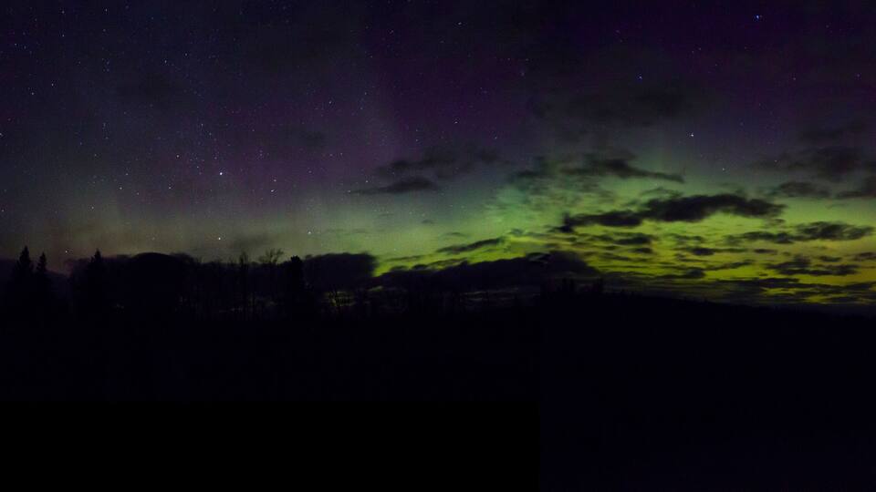 A night sky with stars and the aurora borealis.