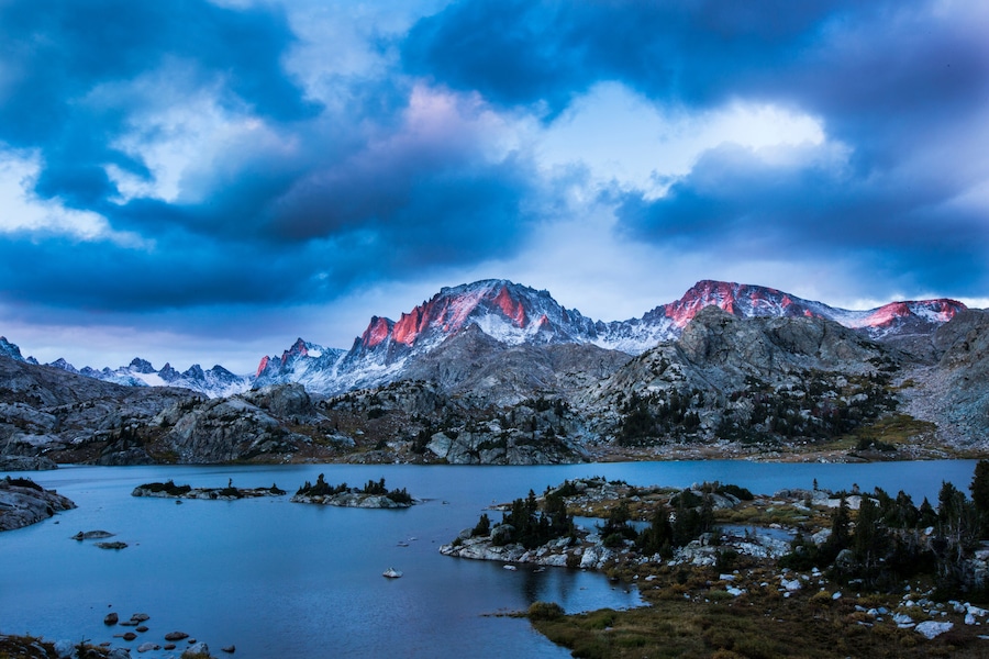 Paisagem montanhosa com um lago e picos nevados.