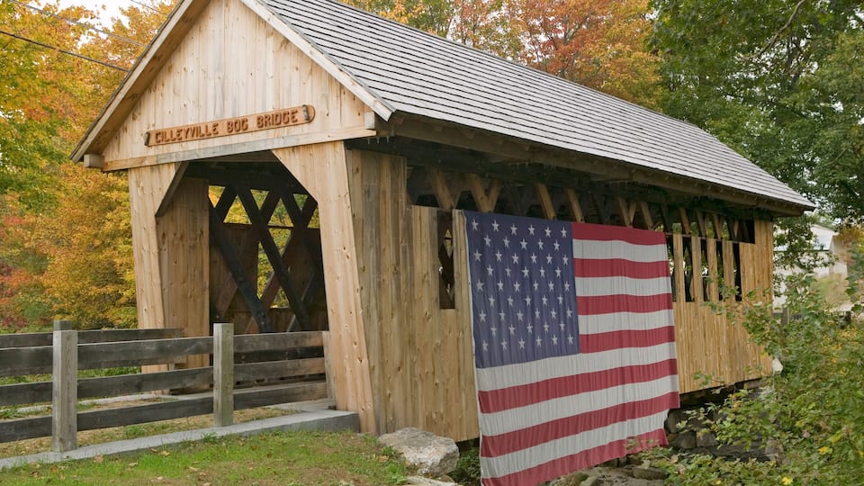 A wooden covered bridge named 'Cilleyville BOC Bridge' with an American flag hanging on it.