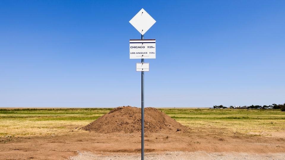 A signpost with distance markers for Chicago and Los Angeles.