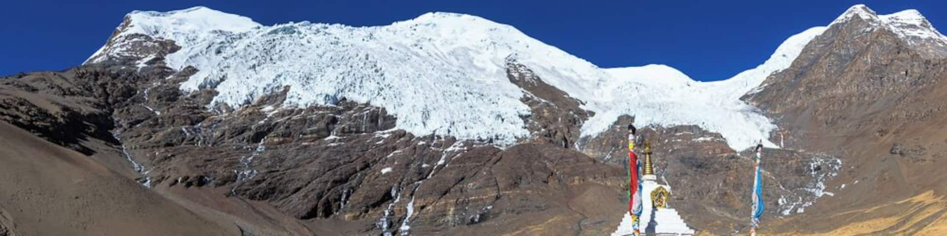 A snow-capped mountain, a shrine, and a clear blue sky.