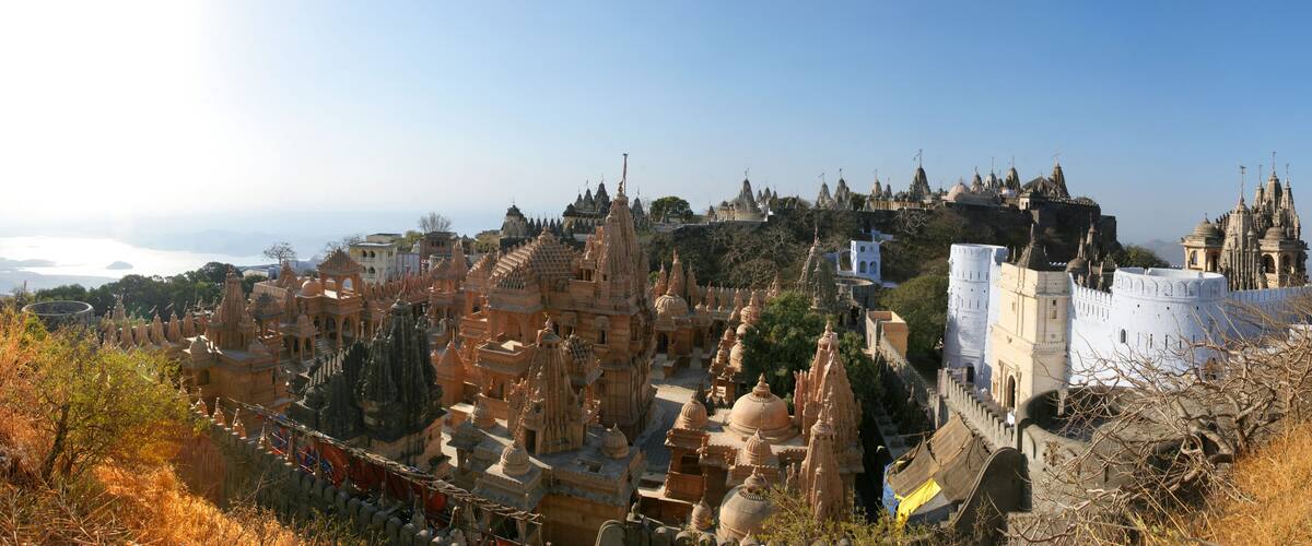 A historic cityscape with intricate architecture and a prominent hilltop fortress.