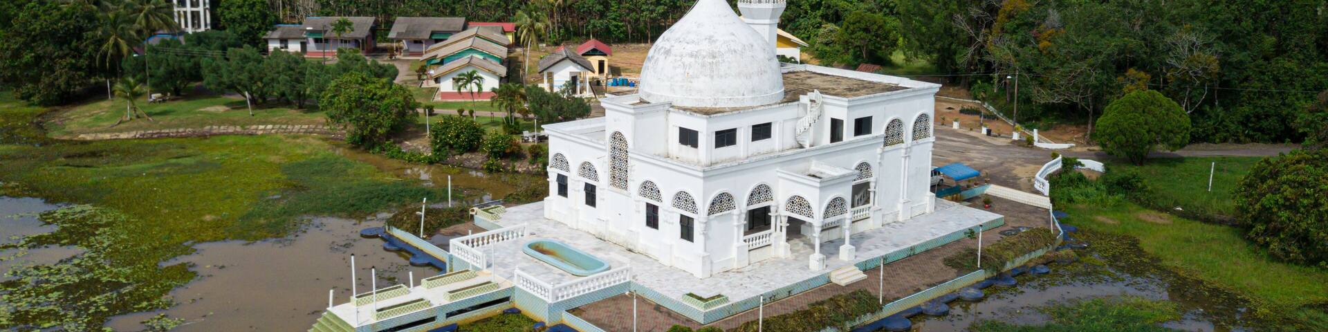 Drone shot of a white mosque from high angle view at Danau Tok Uban, Tanah Merah, Kelantan, Malaysia.