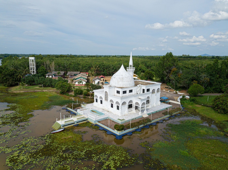 Drone shot of a white mosque from high angle view at Danau Tok Uban, Tanah Merah, Kelantan, Malaysia.