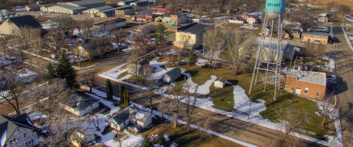 A town with a prominent water tower labeled "BRYANT" amidst residential houses and industrial buildings.
