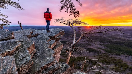 Man, person, standing on a rock high above a valley watching the sun setting in the distance, Pulpit Rock, Cheaha State Park, Alabama