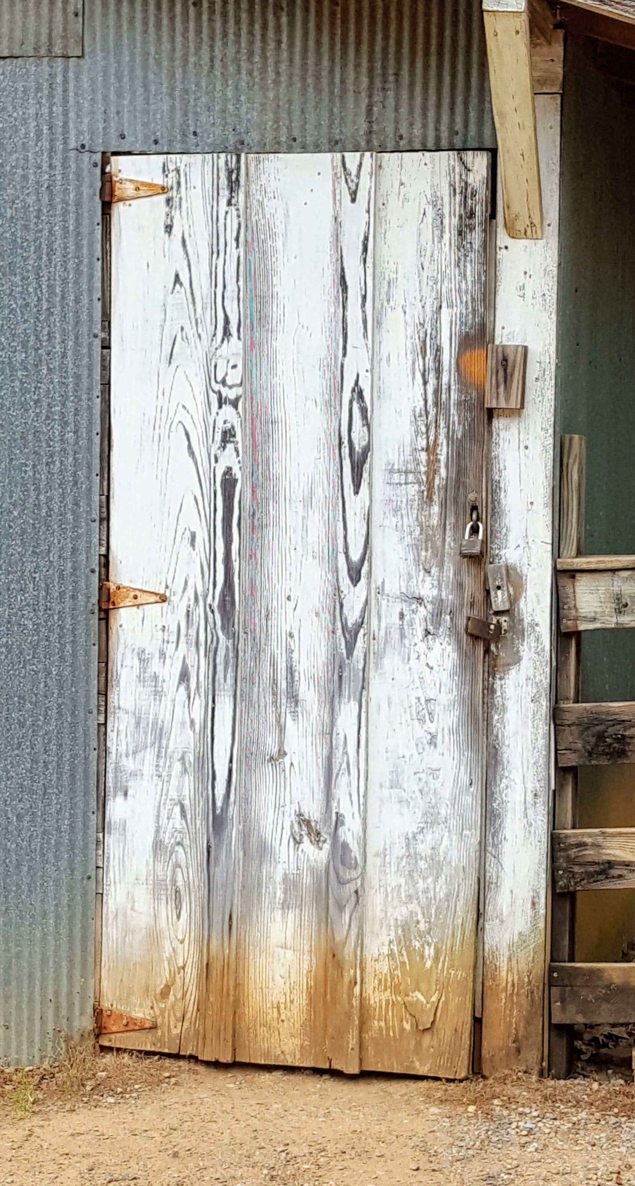 I was riding in my Jeep down an old red dirt road and I spotted an old falling down shed. I looked around, but I left with just this photo of the door, which was hanging in there pretty good, considering.  Gotta love old red dirt roads! #MyBackyard #door #wood #hinges #tin #whitewash #Alabama #America #TheSouth