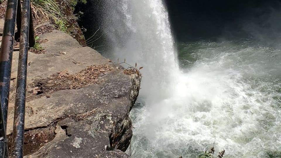 A waterfall cascading over a rocky cliff into a river.