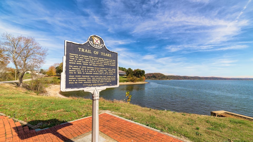 A historical marker titled 'Trail of Tears' by a lake.