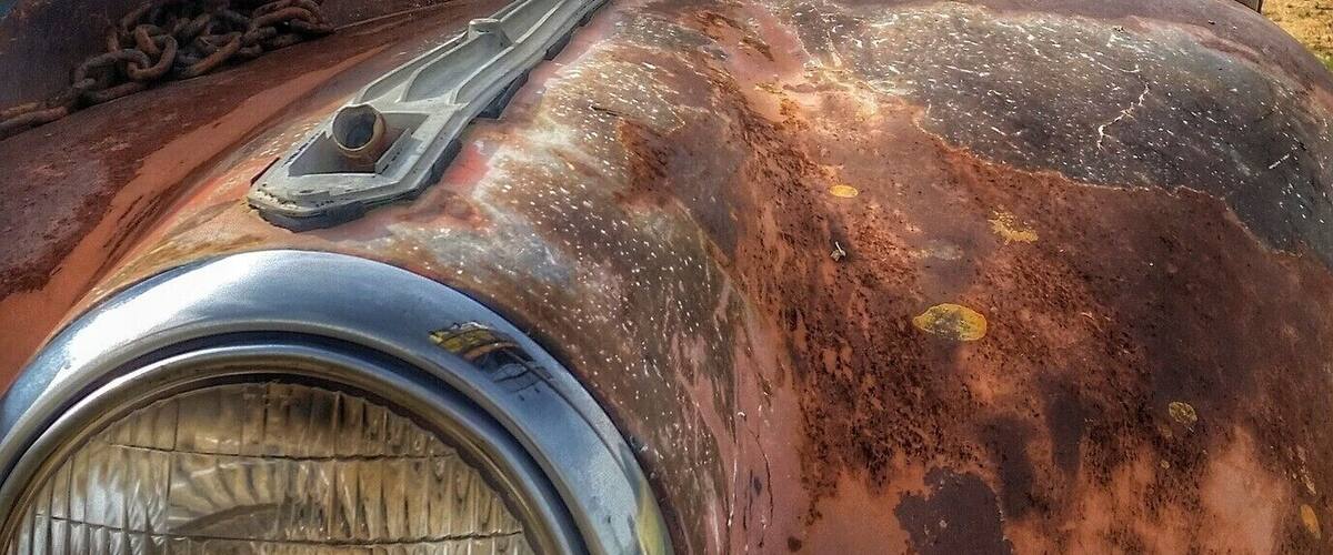 A rusty, abandoned vehicle with visible rust and damage.