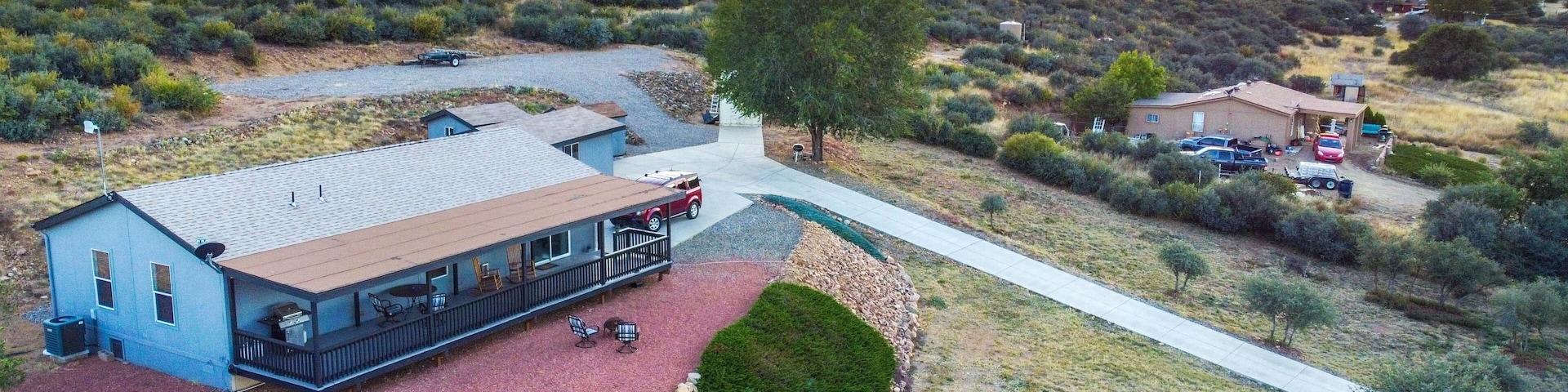 Un quartier résidentiel où se trouve une maison dotée d’un patio couvert, d’une allée en gravier et d’un toit recouvert de tuiles rouges.