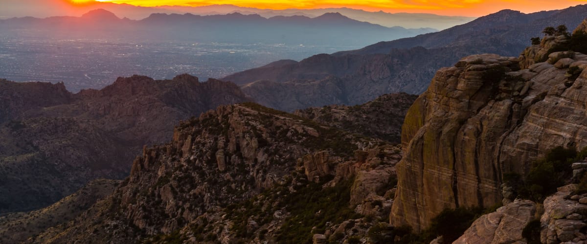 A mountainous landscape with rocky outcrops and a city in the valley below.