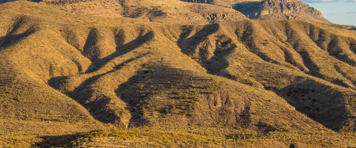 A rugged mountain landscape with distinct ridges and a clear sky.