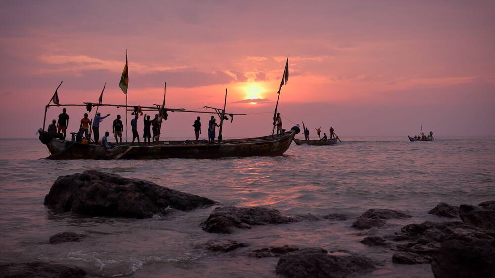 Fishing boat and fishermen at sunrise in Senya Beraku, Ghana