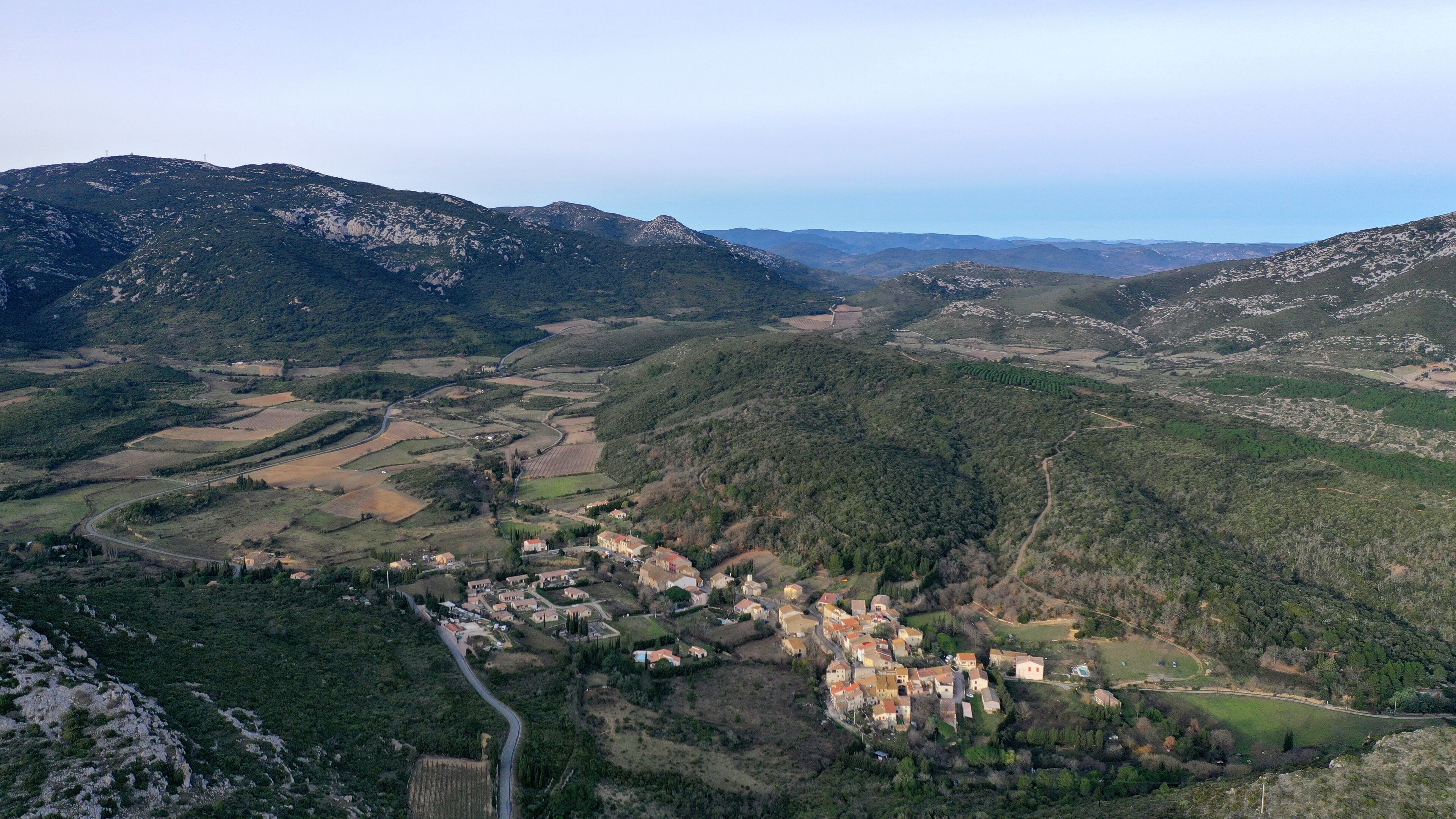 A mountainous landscape with a village nestled in the valley.