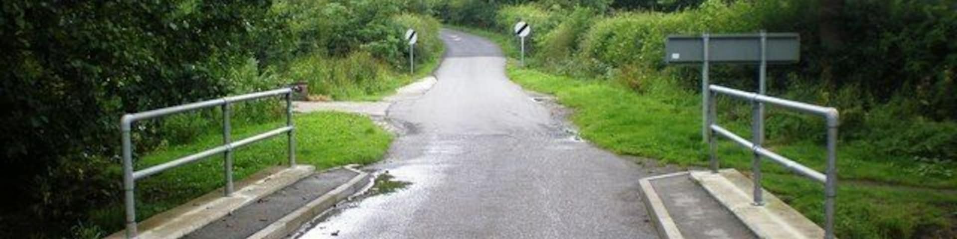 Minor road near Goodmanham, East Riding of Yorkshire, England. This shows the minor road leaving Goodmanham, passing over Mill Beck, and heading southeast before its junction with another minor road.