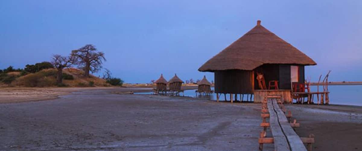 Lodge de Niassam is a eco lodge in paradise! You can live in 3 different cabins; hut on stilts in the lagune, a tree hut in a Baobab tree or a beautiful cabin on the ground. 
Read more on: http://www.travelwithallsenses.com/lodge-de-niassam-eco-lodge-paradise/