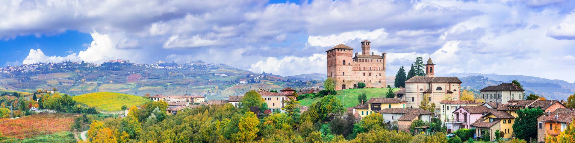 Ultra-wide 15K panorama of Castello di Grinzane Cavour in Piedmont. Medieval castle and rolling Barolo vineyards, UNESCO World Heritage, Italy.