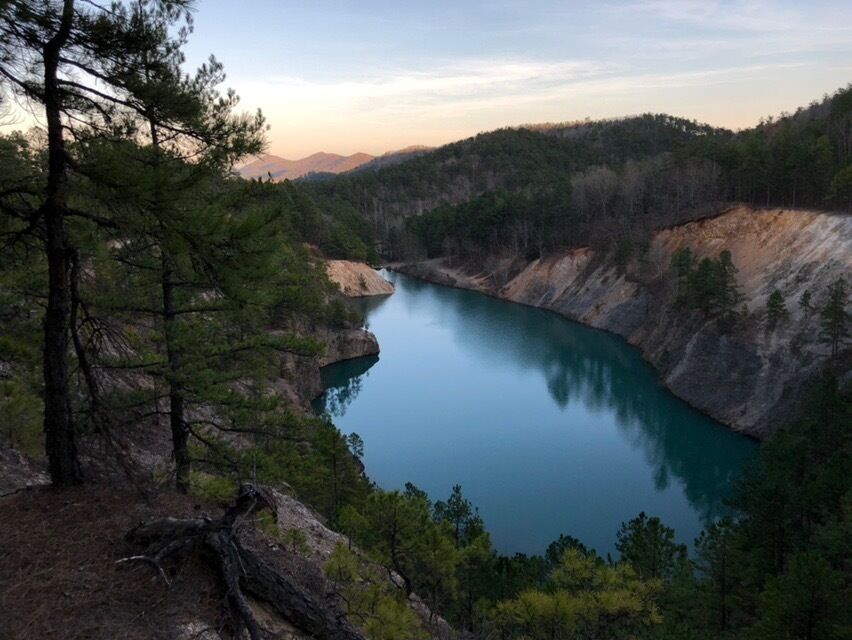A serene lake surrounded by forested hills.