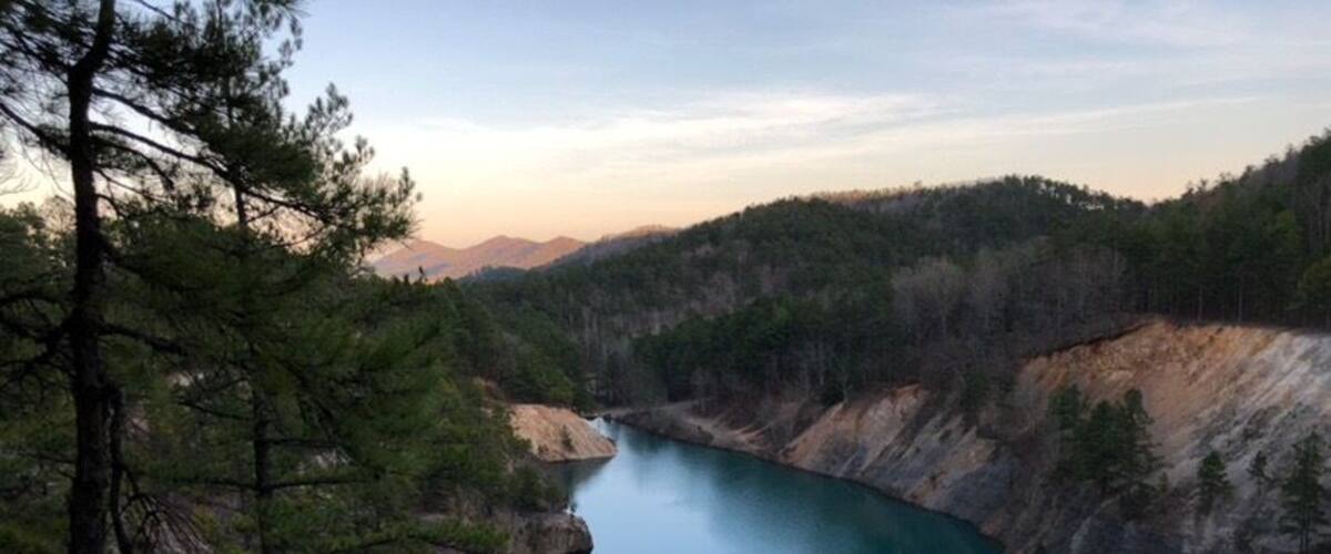 A serene lake surrounded by forested hills.