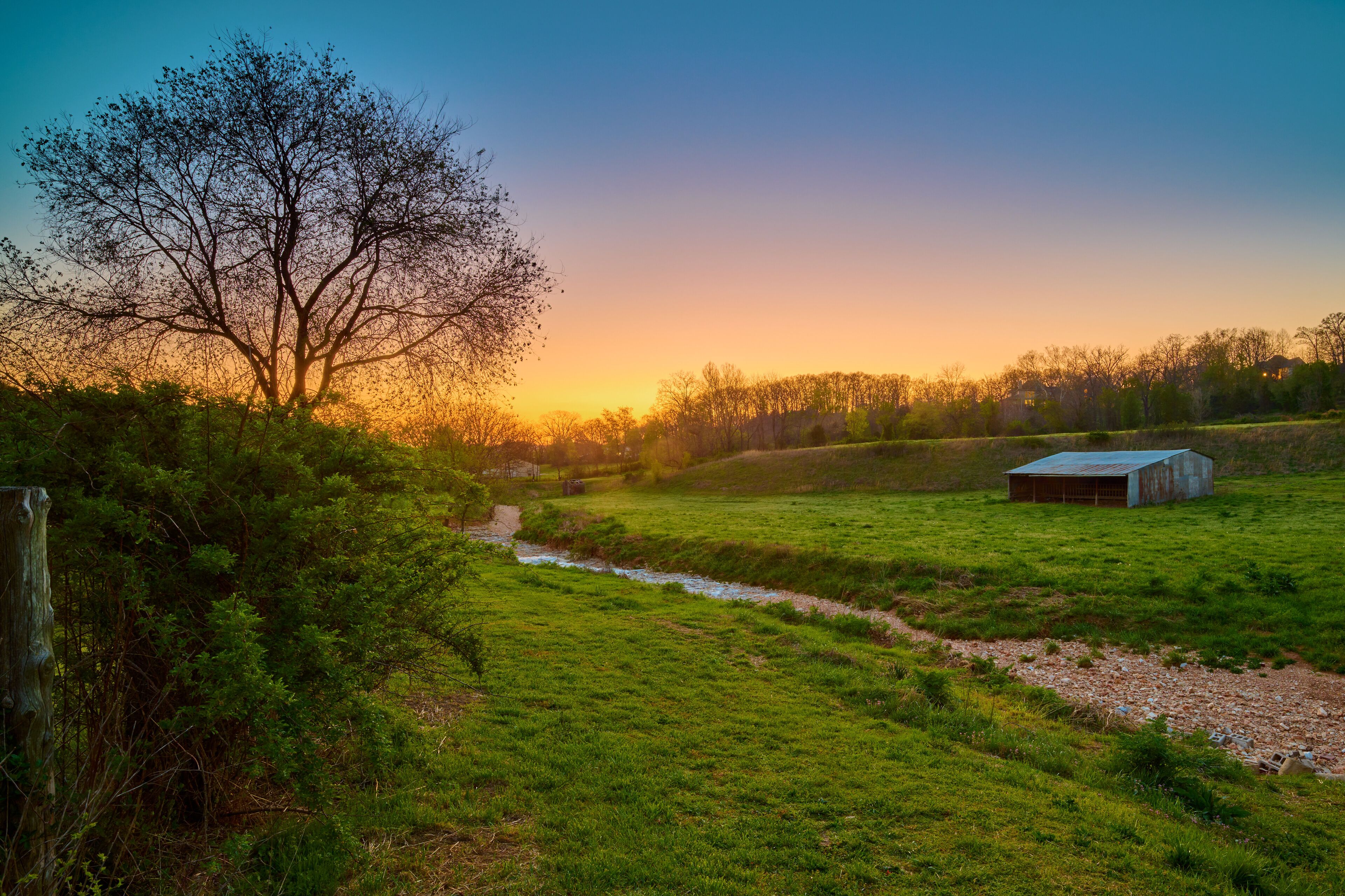 Sunset over a farm with old barn near Bentonville Arkansas.