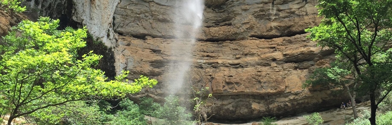 Hemmed-in Hollow is one of the beautiful waterfalls located in the Buffalo River Wilderness Area.  
This towering waterfall is best accessed from the river.  The trail is located between Steele Creek and Kyle's Landing, both popular camp areas and river access points along the Buffalo National River.  I don't think the trail is marked, but it's not a secret and there are usually plenty of people who can guide you on where to stop.  It's about a 1.5 mile trip each way with a little elevation gain...but not a difficult hike.
You can reach Hemmed-in Hollow over land, but that is a more strenuous hike.