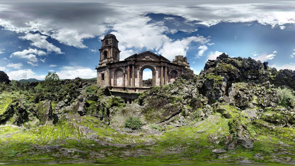 An ancient stone church with a bell tower, surrounded by rocky terrain and greenery.