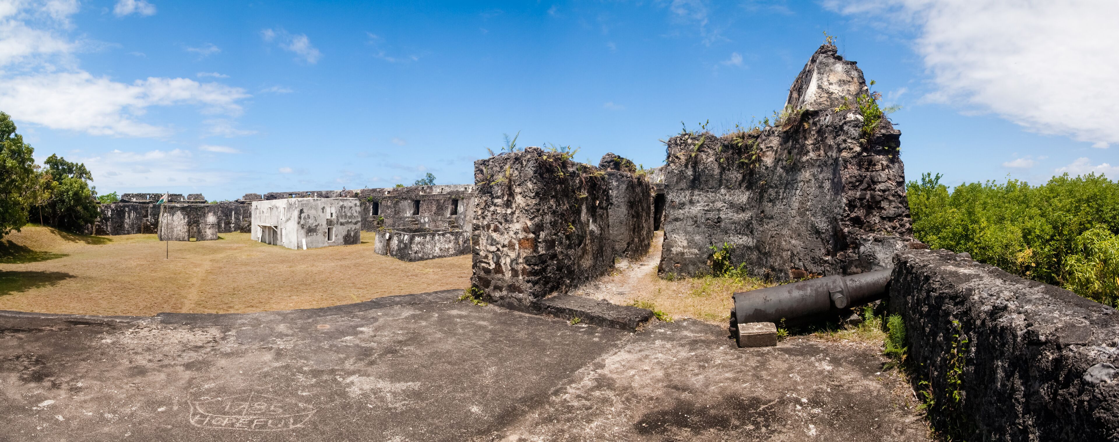Ancient ruins with stone structures and a large pipe.
