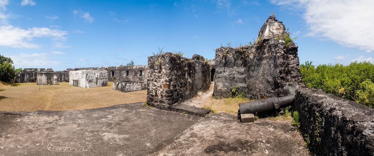 Ancient ruins with stone structures and a large pipe.
