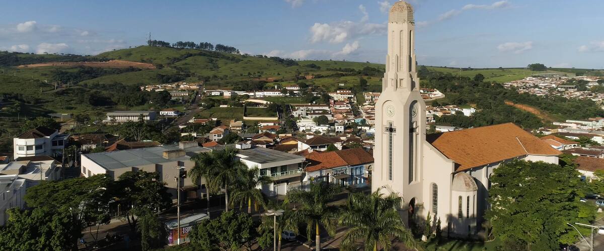 A church with a tall tower, surrounded by residential buildings and greenery.