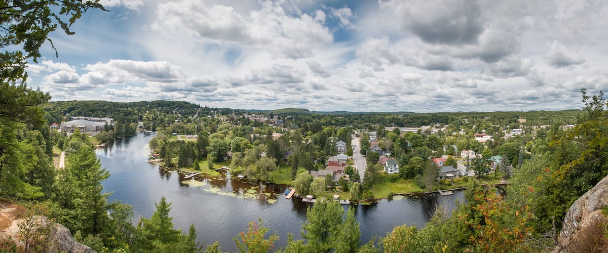A river winding through a town surrounded by dense forests and hills.