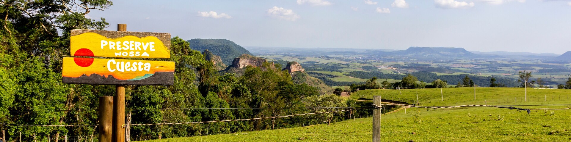 View of the relief and rocky slopes of the tourist region called Polo Cuesta, from the Pedra do Indio lookout, located in Botucatu, state of Sao Paulo, Brazil. Sign in Portuguese: preserve our cuesta