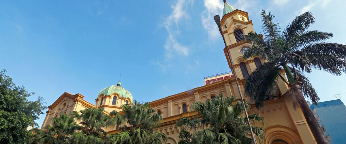 A historic church with a green dome and a tall bell tower.