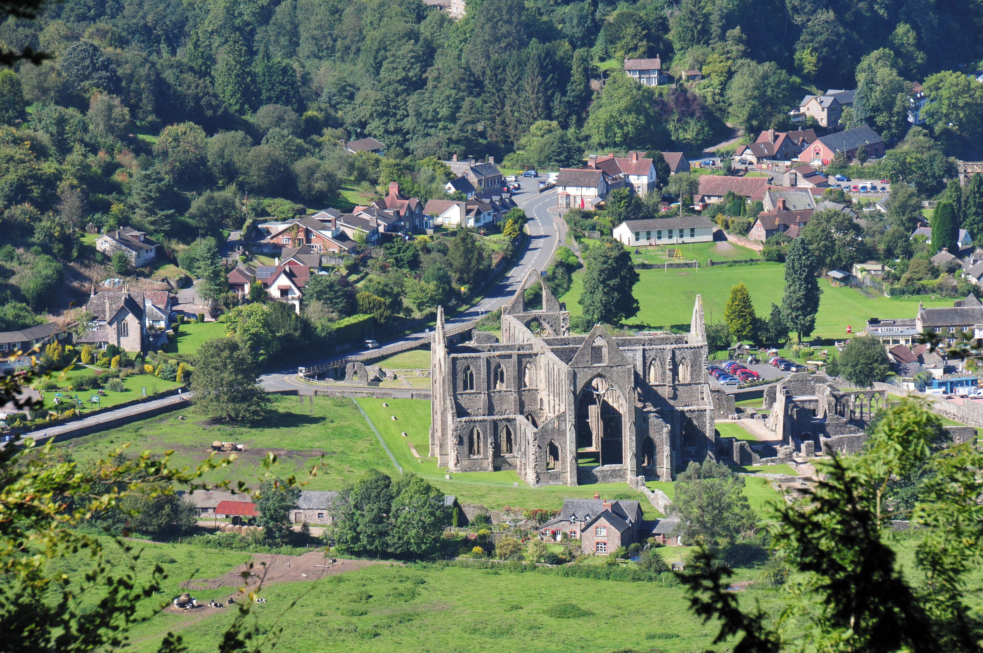 A historic church with ruins, surrounded by a small village with houses and a road.