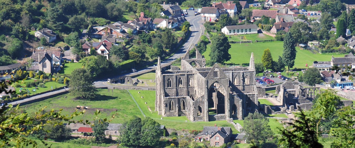 A historic church with ruins, surrounded by a small village with houses and a road.