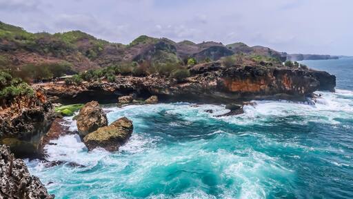 The cliff edge of a beach with big waves during the day