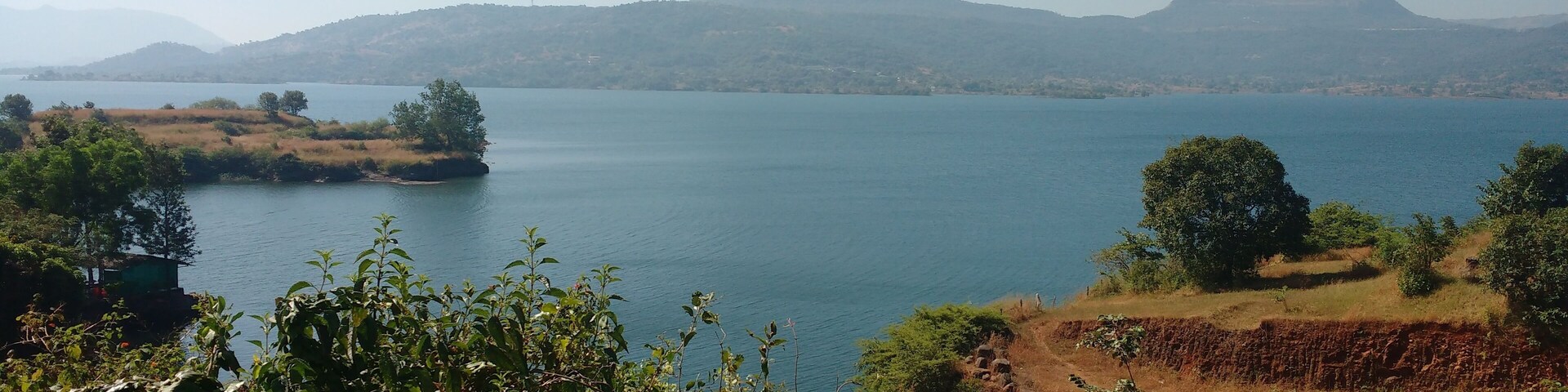 A lake surrounded by hills and trees.
