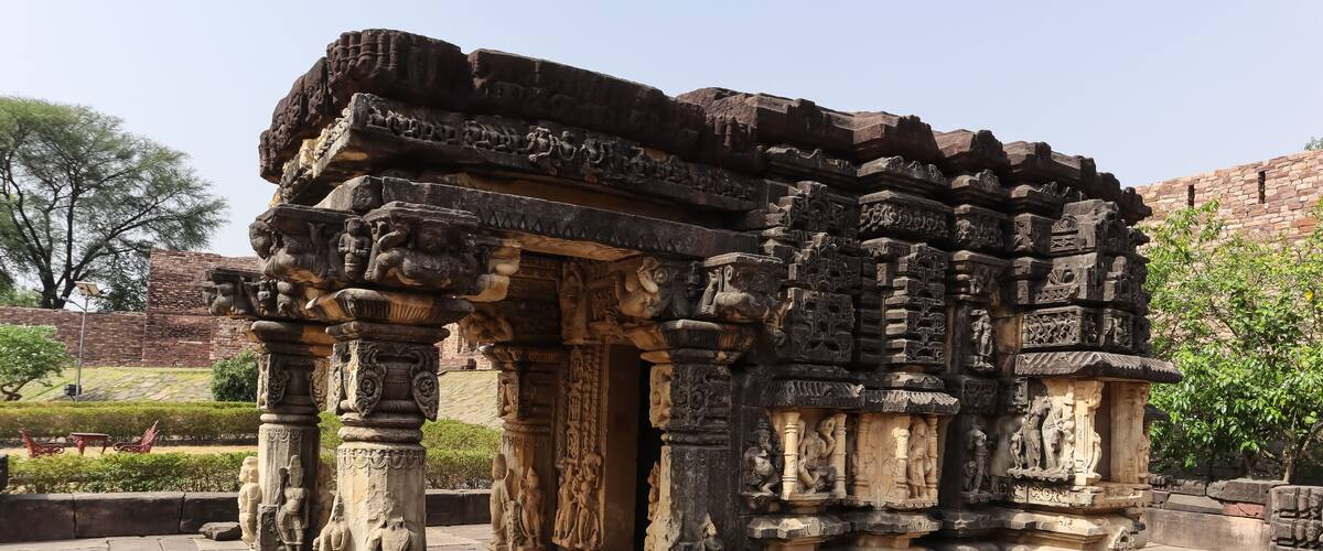 An ancient stone structure with intricate carvings and columns.