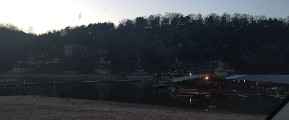 A riverside area with a dock and a building with a roof.